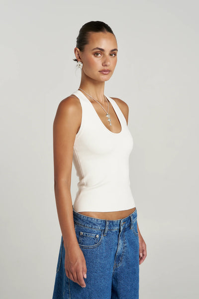 A three-quarter profile studio shot of the Summi Summi Halle Tank in Vanilla, highlighting its clean scoop neckline, wide straps, and premium organic cotton knit construction.