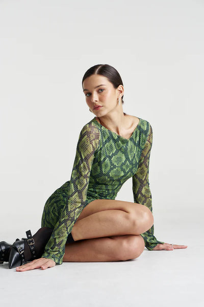 Sitting pose showcasing how the A-line mini dress holds its shape, highlighting the durability of the polyester-spandex mesh blend.